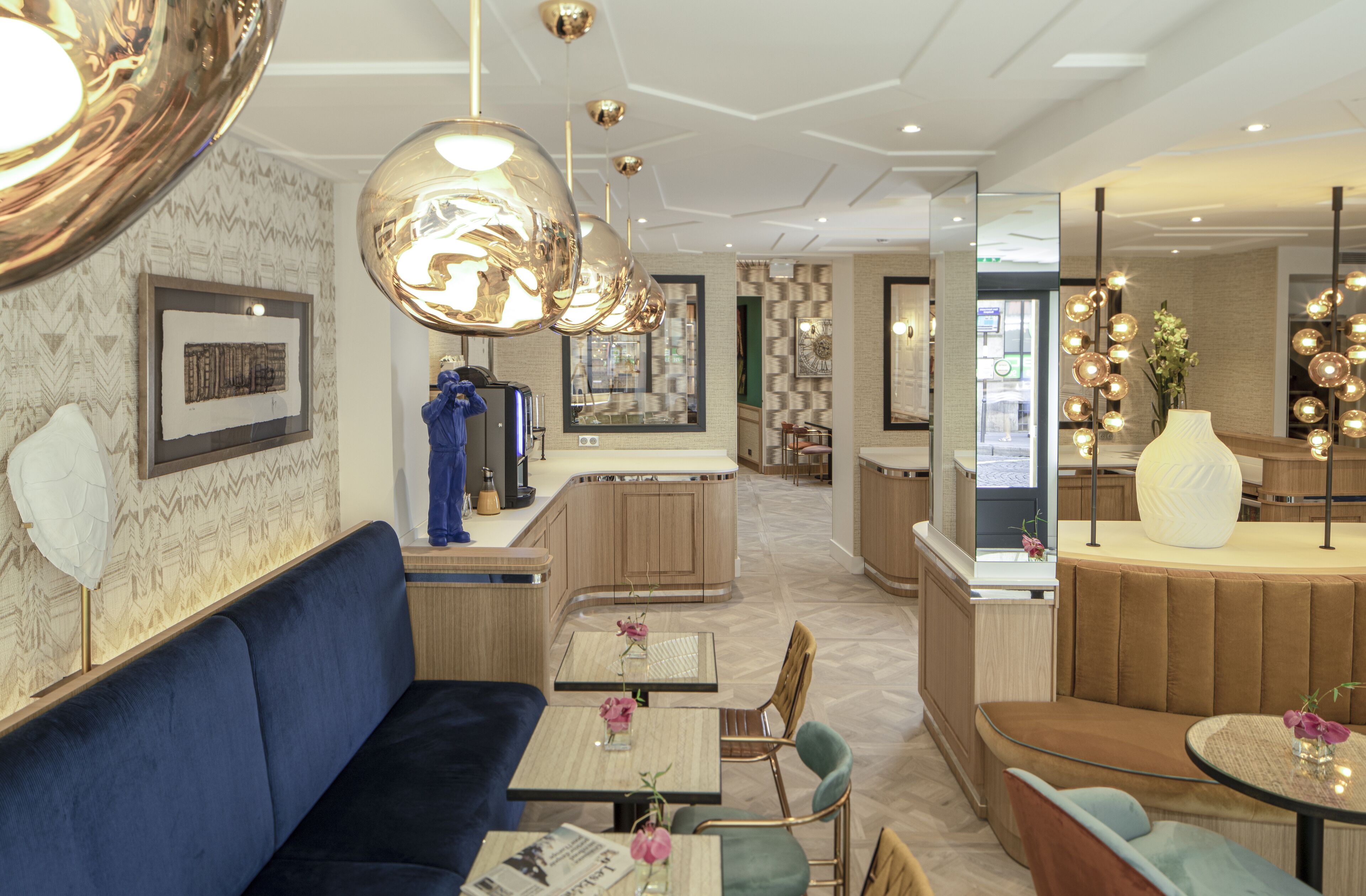 A modern hotel lobby with a seating area, a bar, and a reception desk.