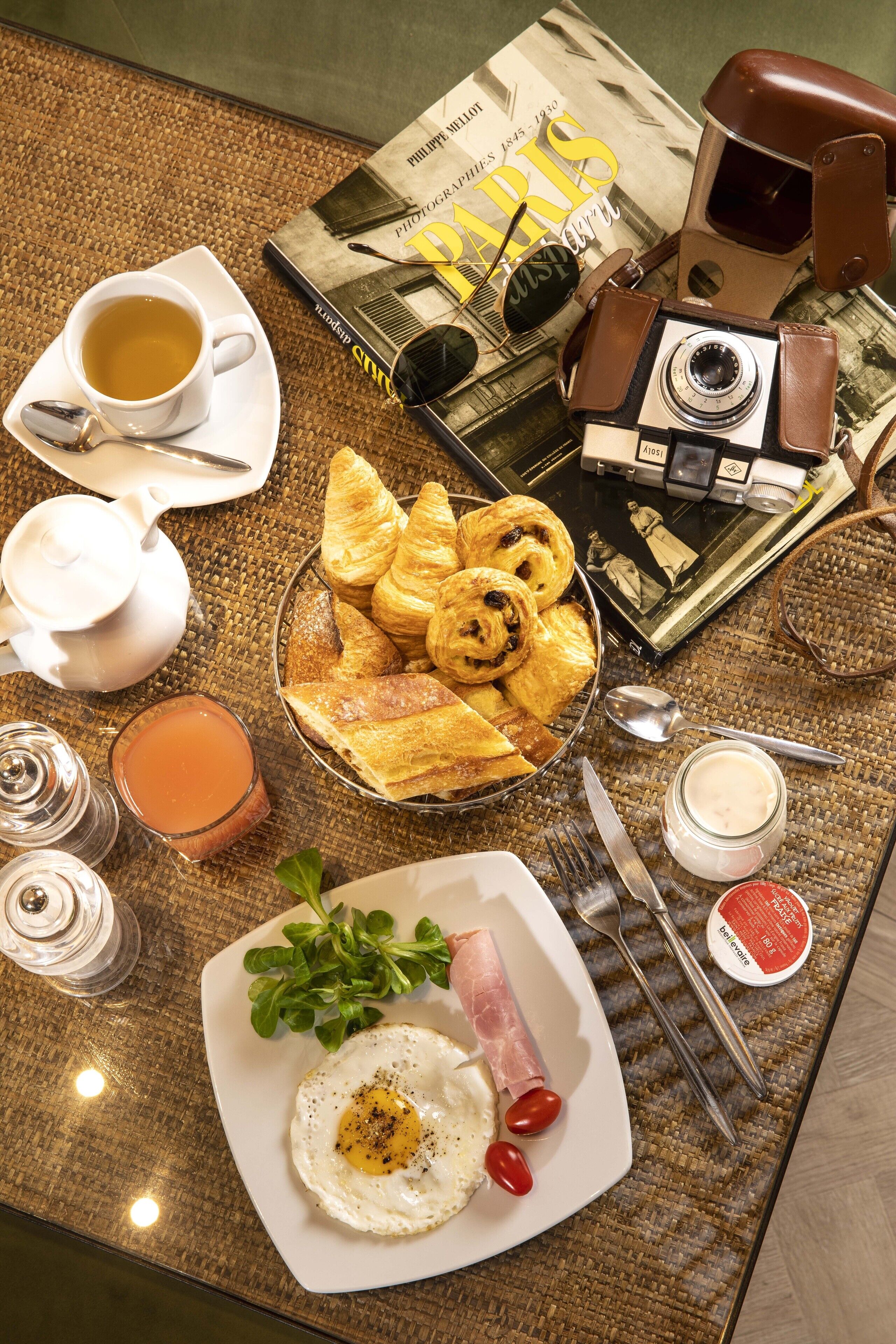 Een ontbijt met croissants, een bord met een gebakken ei en een kop koffie op een geweven tafelkleed.
