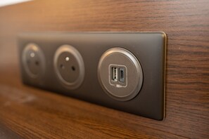 A wall-mounted electrical outlet with three sockets and a USB port. - Le Relais De Montigny - Logis (Montigny)