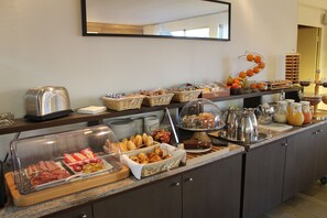 A buffet with various food items and beverages, including hot dogs, pastries, and fruit. - Le Relais De Montigny - Logis (Montigny)