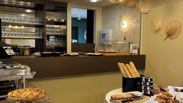 A buffet setup with pizzas and bread, a coffee machine, and a glassware display. - Le Relais De Montigny - Logis (Montigny)