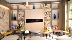 Uma área de estar moderna com lareira, assentos confortáveis e iluminação decorativa.