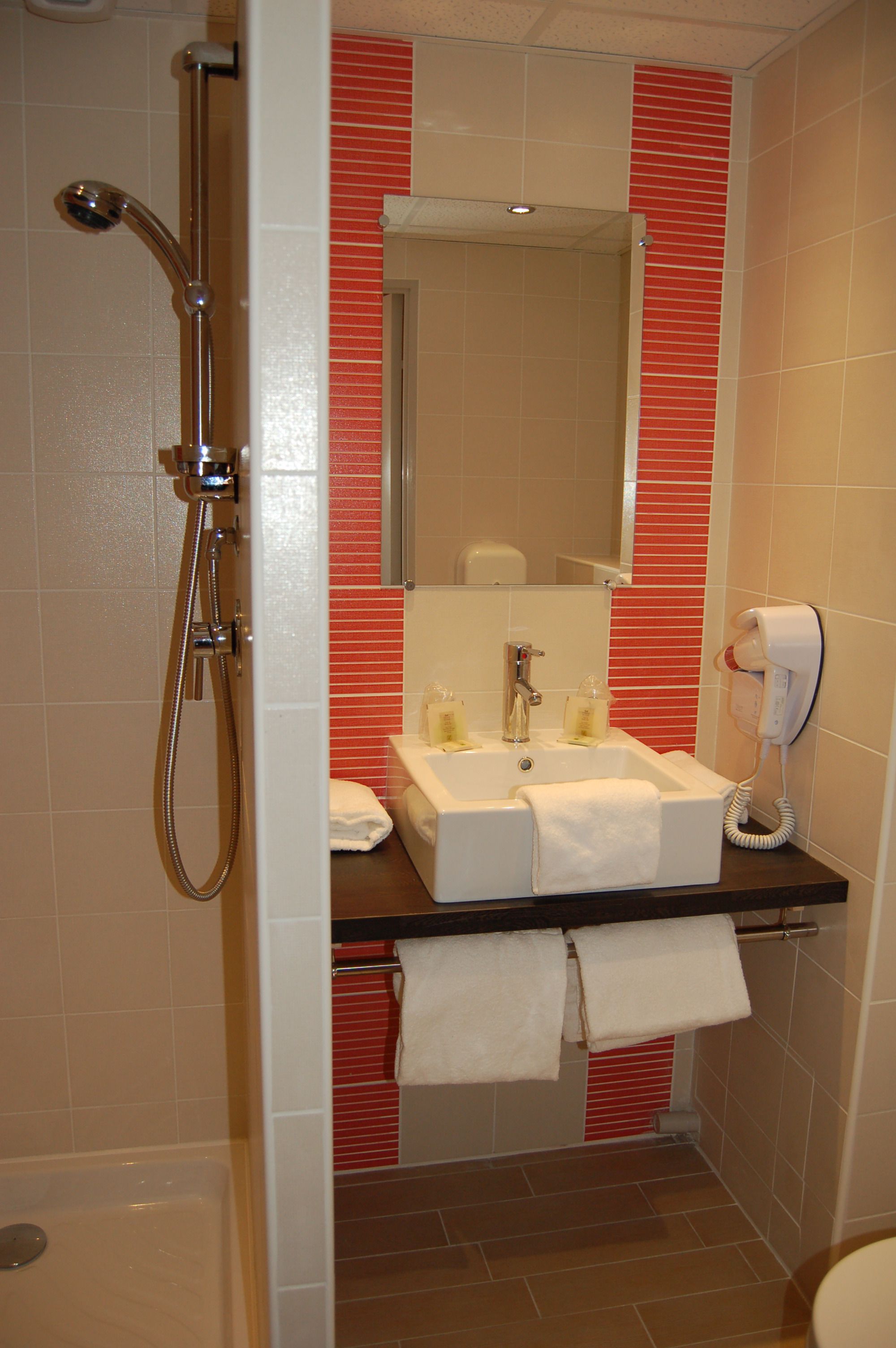 Un baño con ducha, lavamanos e inodoro.