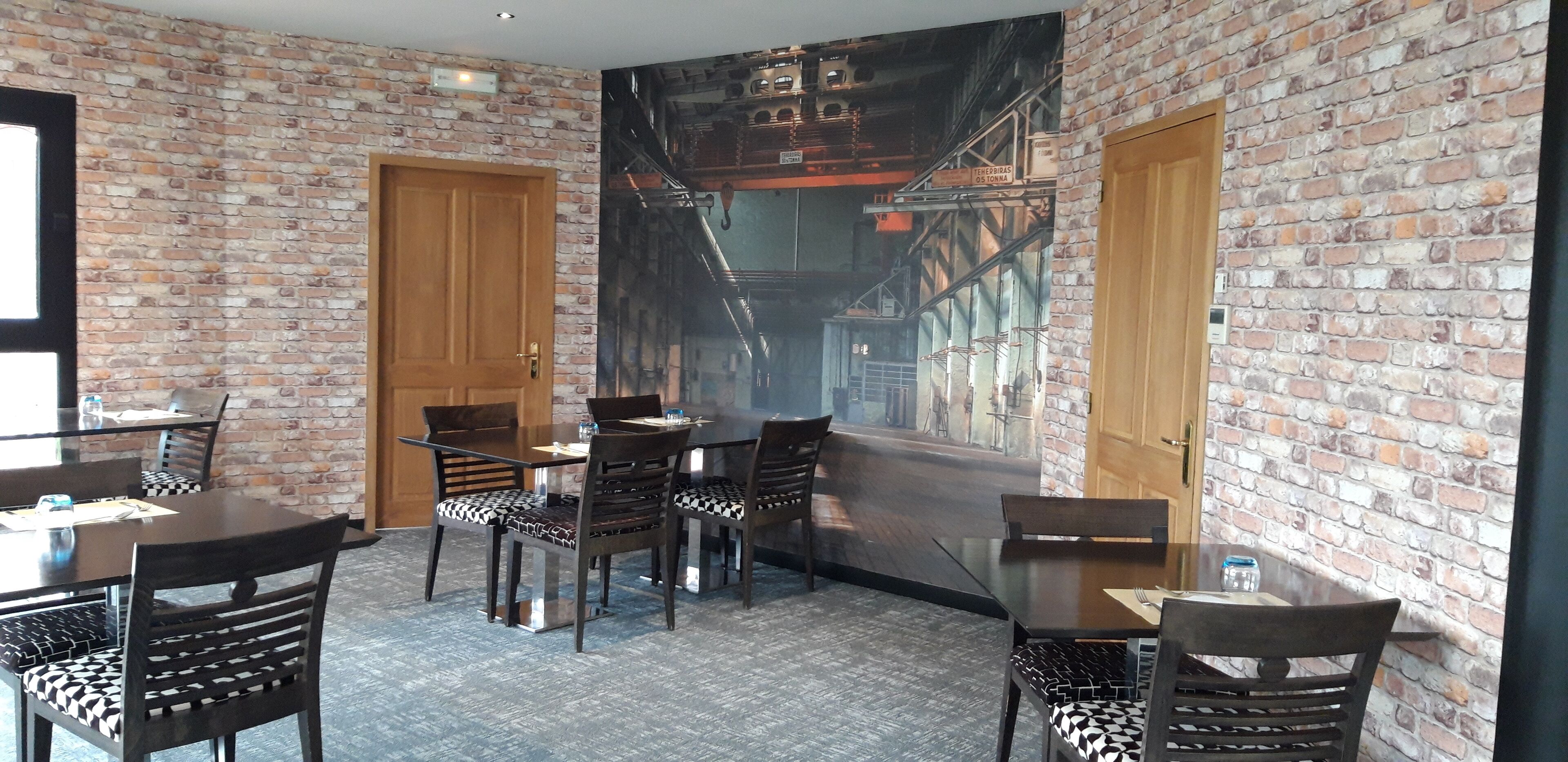 Un restaurante con paredes de ladrillo, puertas de madera y sillas con estampado blanco y negro.