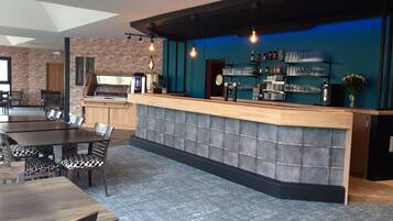 A bar area with a counter, seating, and a brick wall.