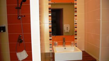 A bathroom with a shower, a sink, and a mirror.