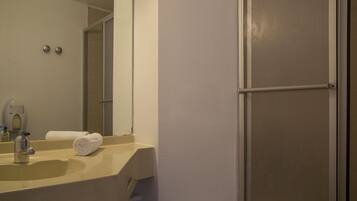 Un baño con lavamanos, espejo y toalla.