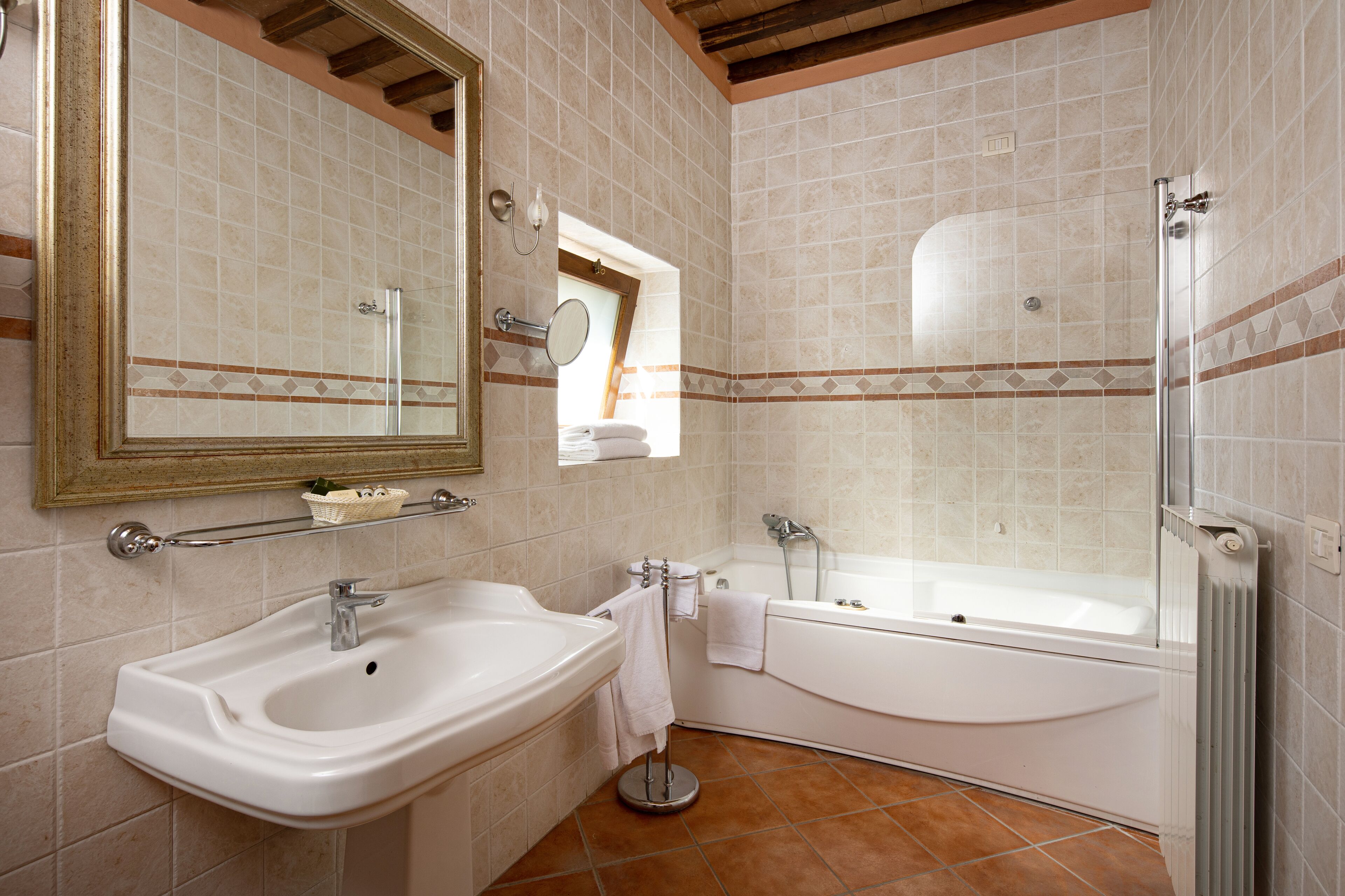 Une salle de bain équipée d’un lavabo, d’un miroir, d’une baignoire et d’une douche.