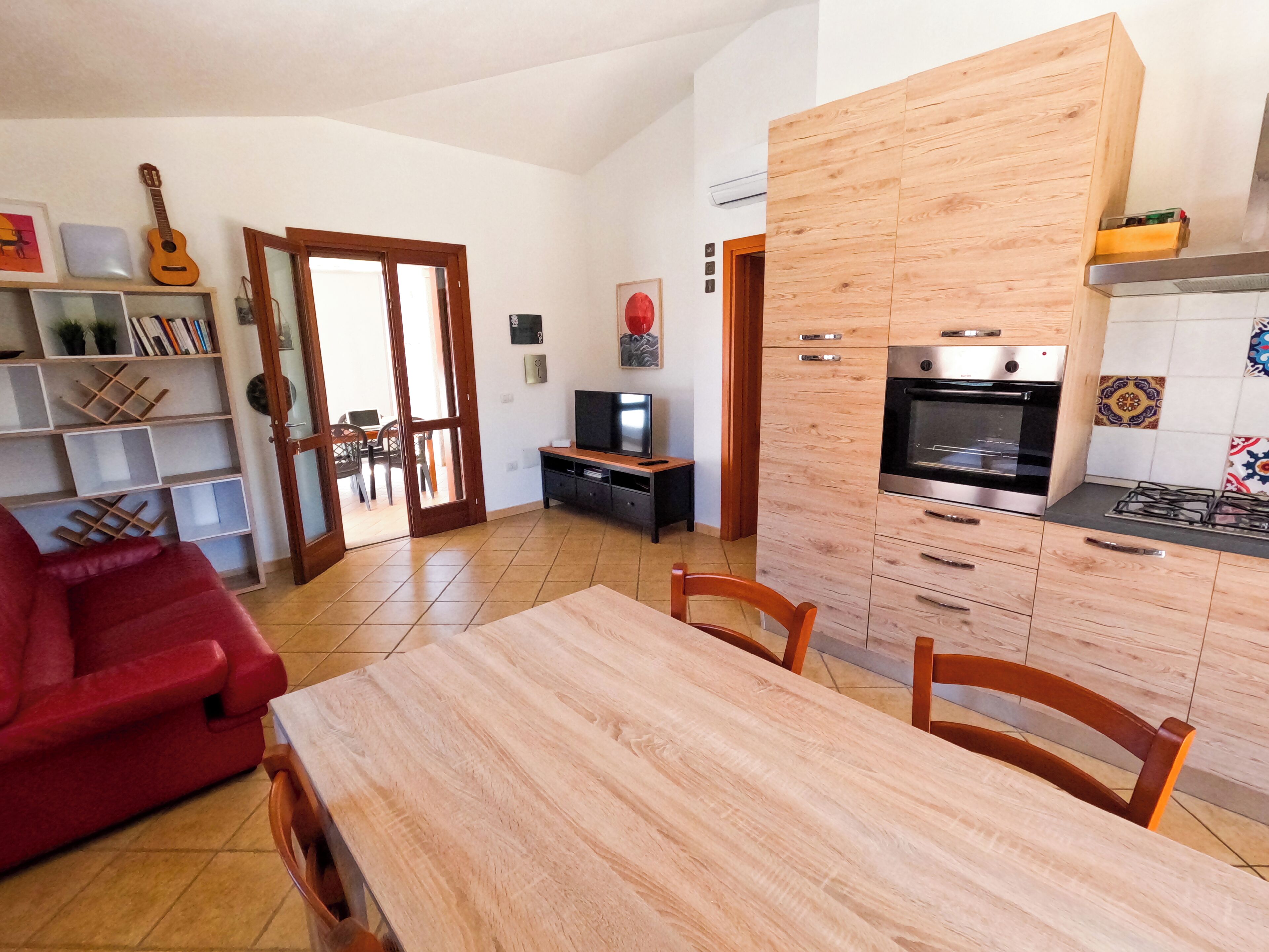 Een moderne keuken met houten kastjes, een eettafel en stoelen.
