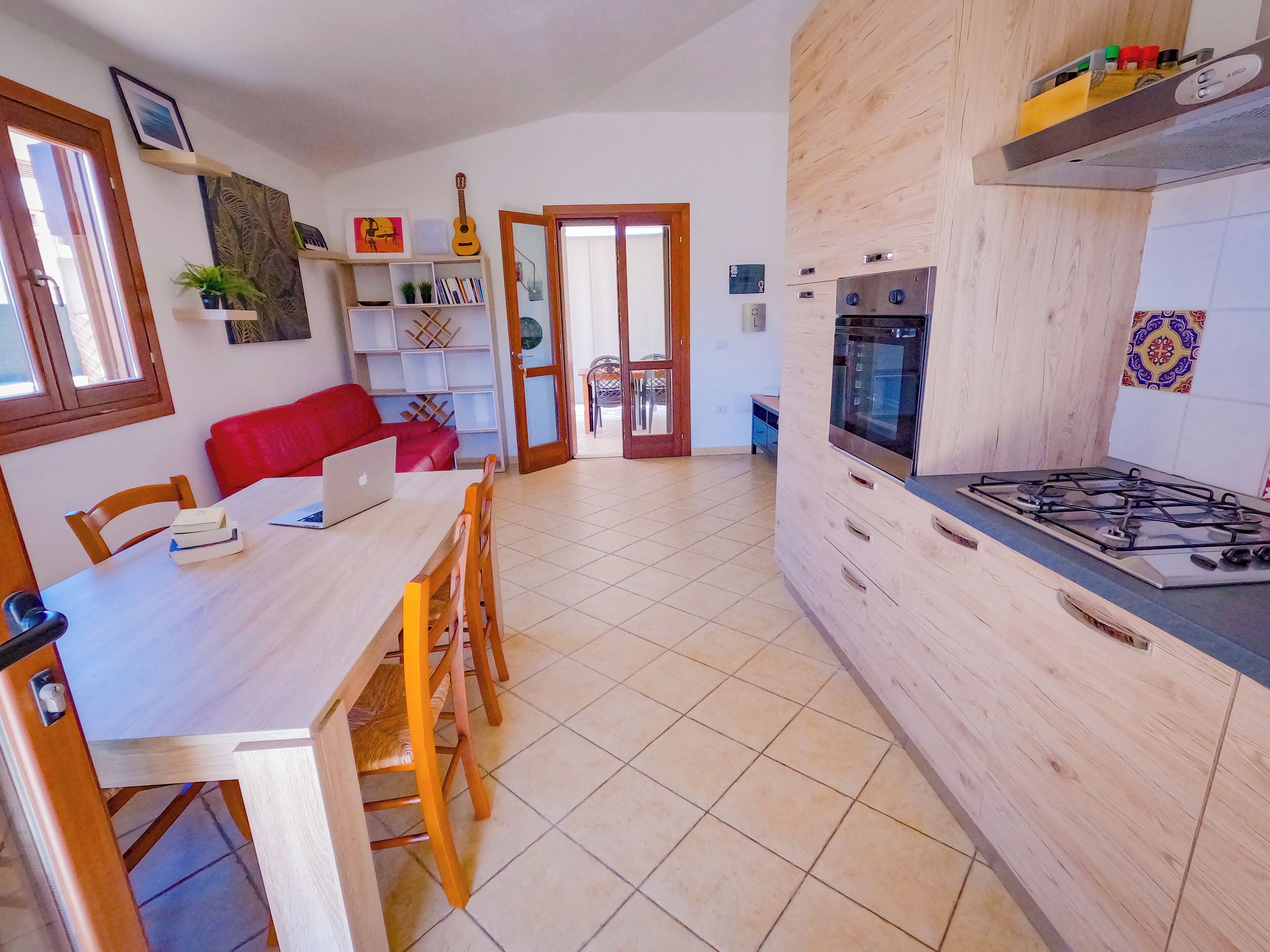 A kitchen with a wooden countertop, a gas stove, and a dining area with a table and chairs.