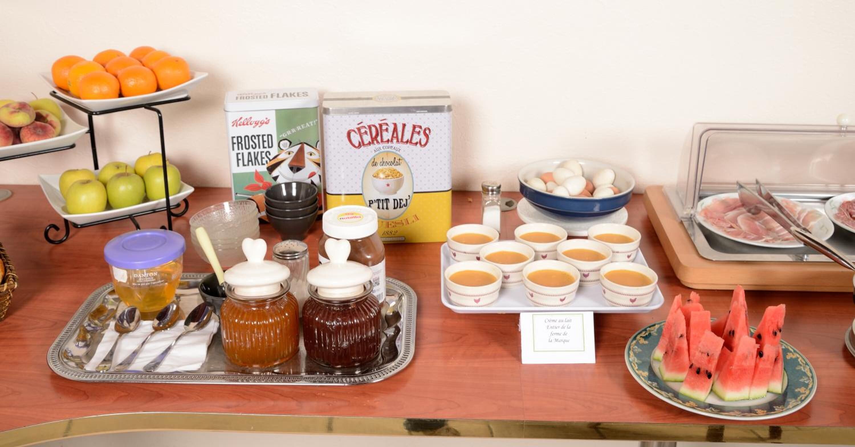 Ein Frühstücksbuffet mit verschiedenen Speisen, darunter Früchte, Getreideprodukte und Würzmitteln.