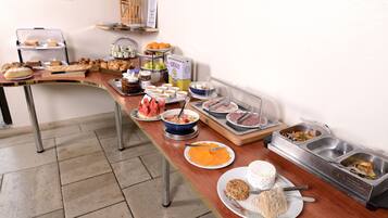 A buffet setup with various food items and containers.