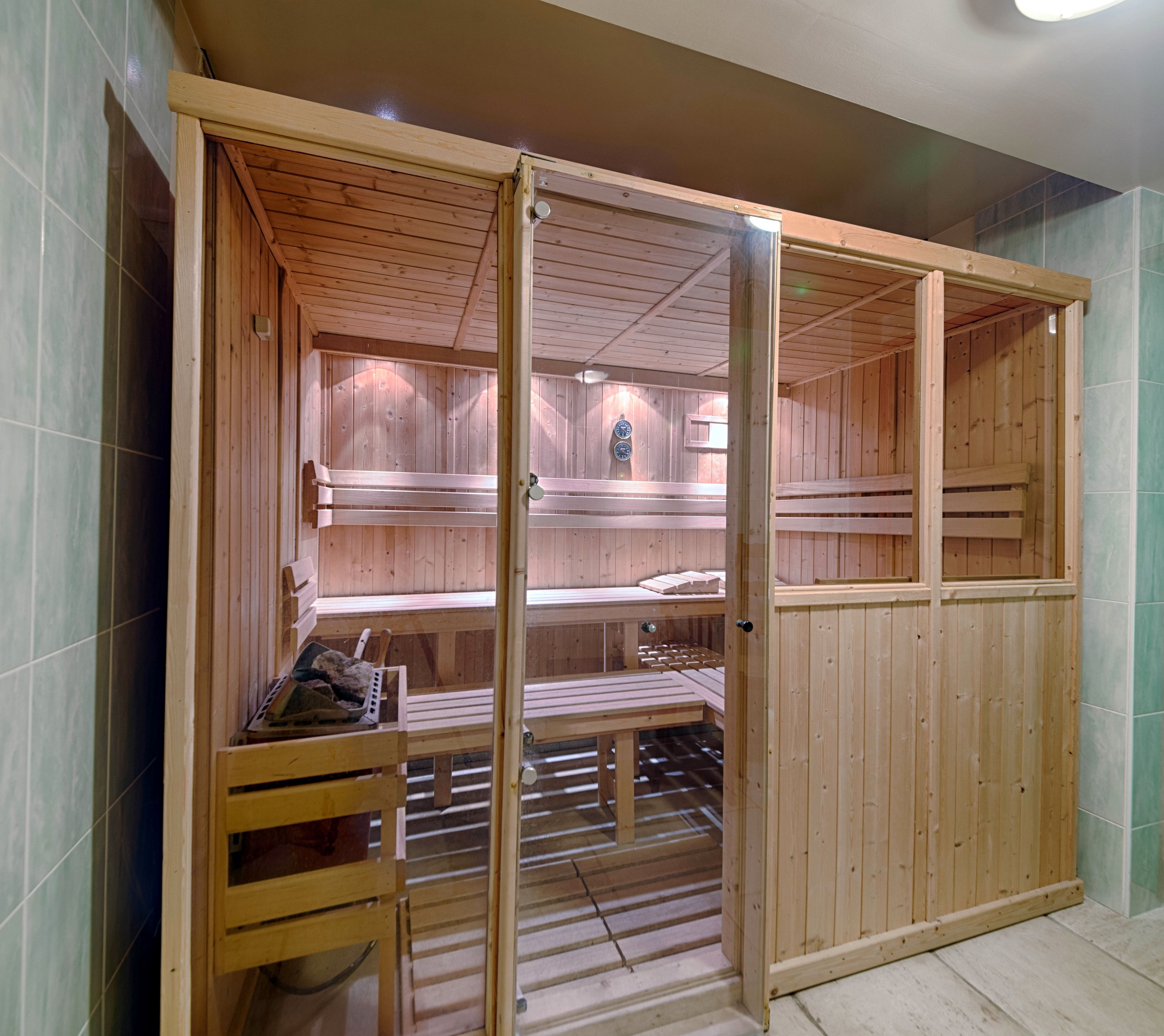 A sauna with wooden benches and a bench with a towel and slippers.