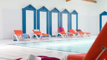 Una piscina techada, sillones reclinables de piscina
