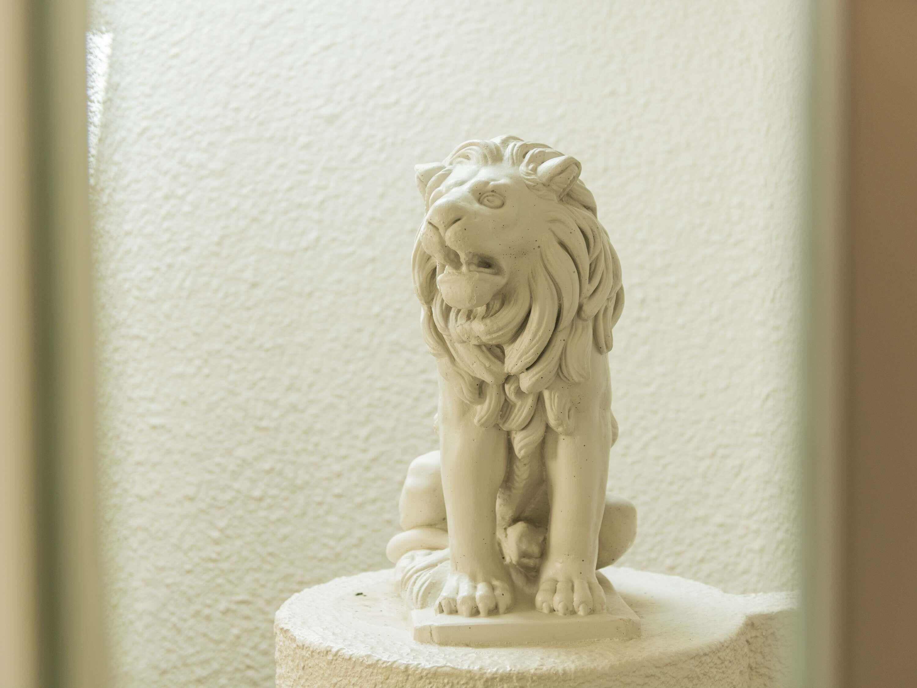 A white lion statue on a pedestal.