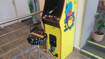 Relax in a fun space with a classic Pac-Man arcade machine and a cozy stool.