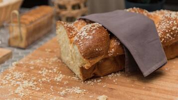 Een brood met een doek erop, op een houten oppervlak met kruimels.