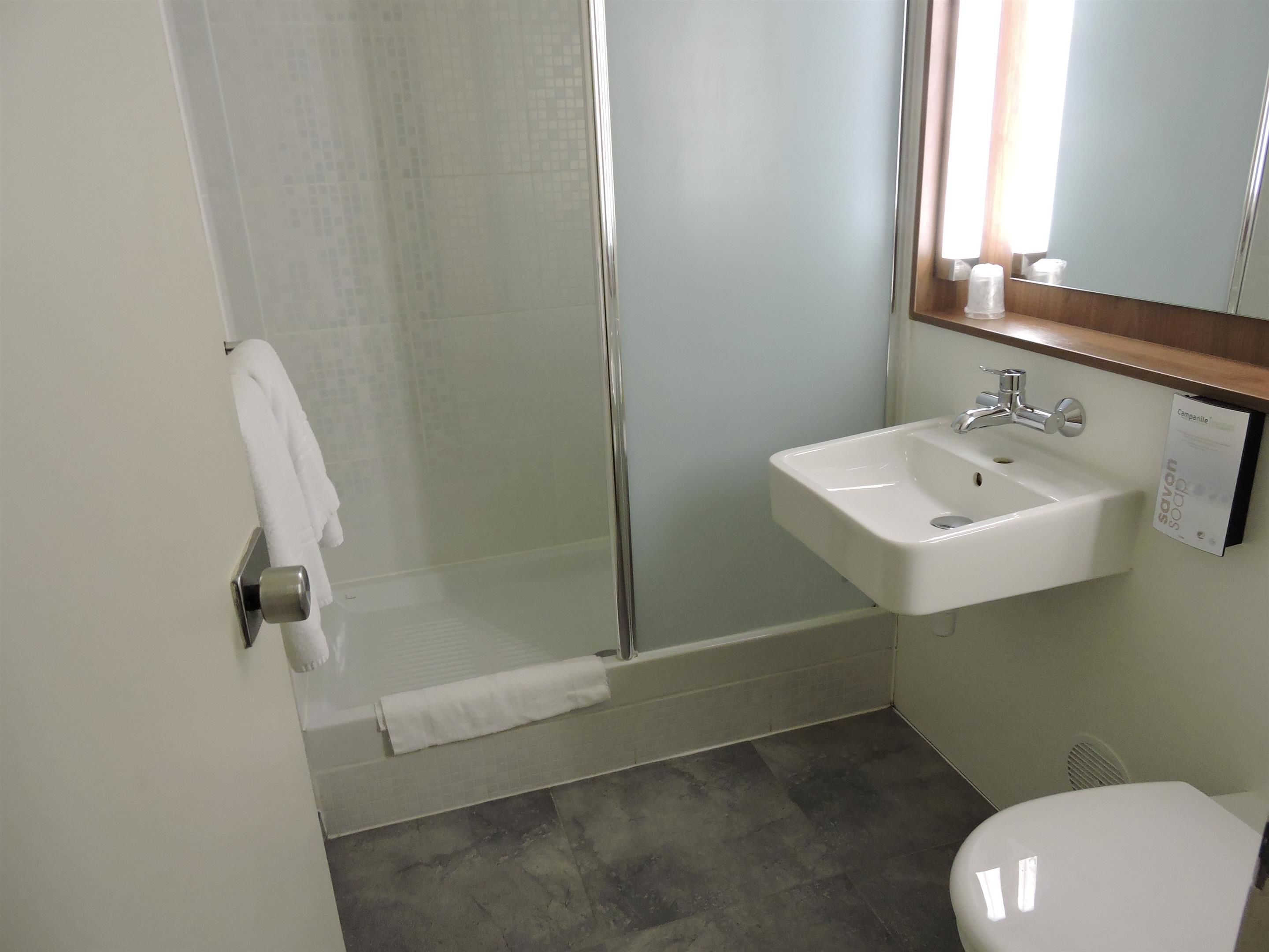 Une salle de bain avec une douche, un lavabo et des toilettes.