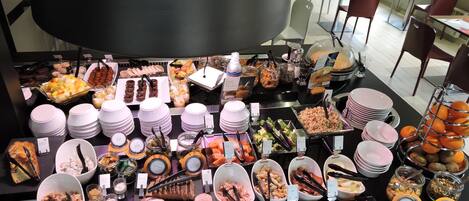 Un bufé con diversos alimentos y utensilios.