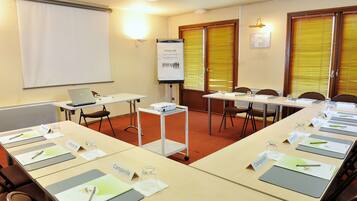 A conference room with a long table, nameplates, and a projector screen.