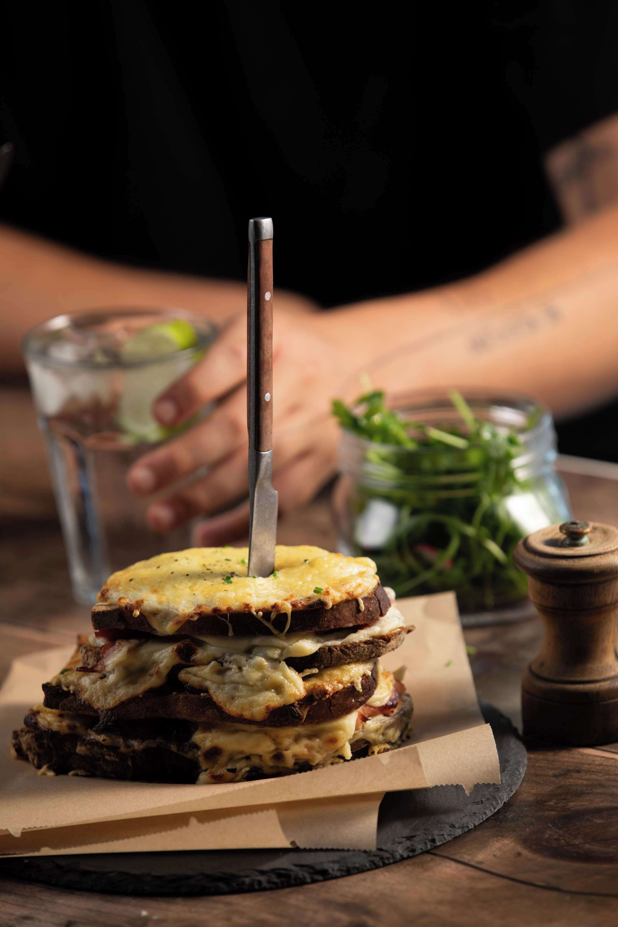 Un panino con un coltello sopra, su un foglio di carta pergamena.