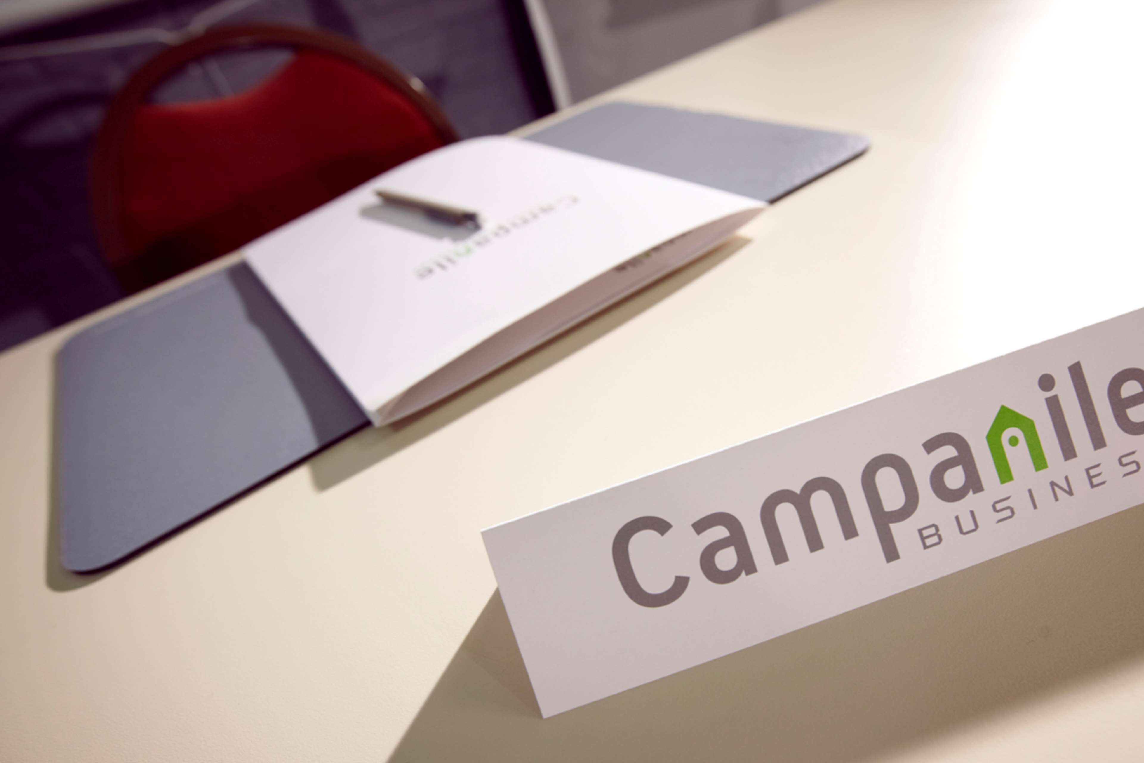 A business card and a folder on a table.