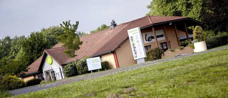 Un bâtiment doté d’un espace d’accueil et d’une enseigne sur laquelle on peut lire « Bienvenue ».