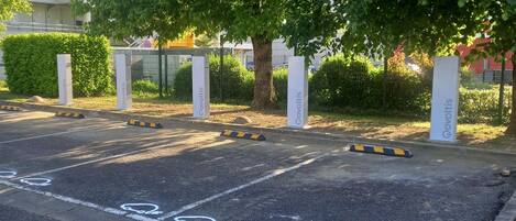 A parking area with marked bicycle lanes and bollards.