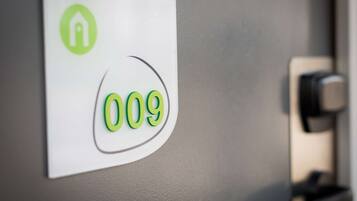 A door with a sign indicating room number 009 and a green icon suggesting a hotel or lodging facility.
