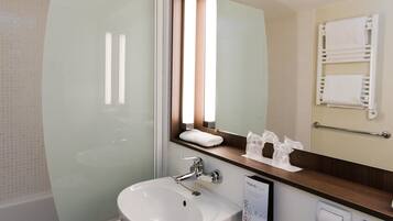 Une salle de bain avec un lavabo blanc, un miroir et un porte-serviettes.
