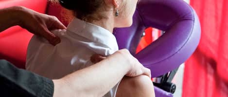 Una persona sentada en una silla morada con un fondo rojo.