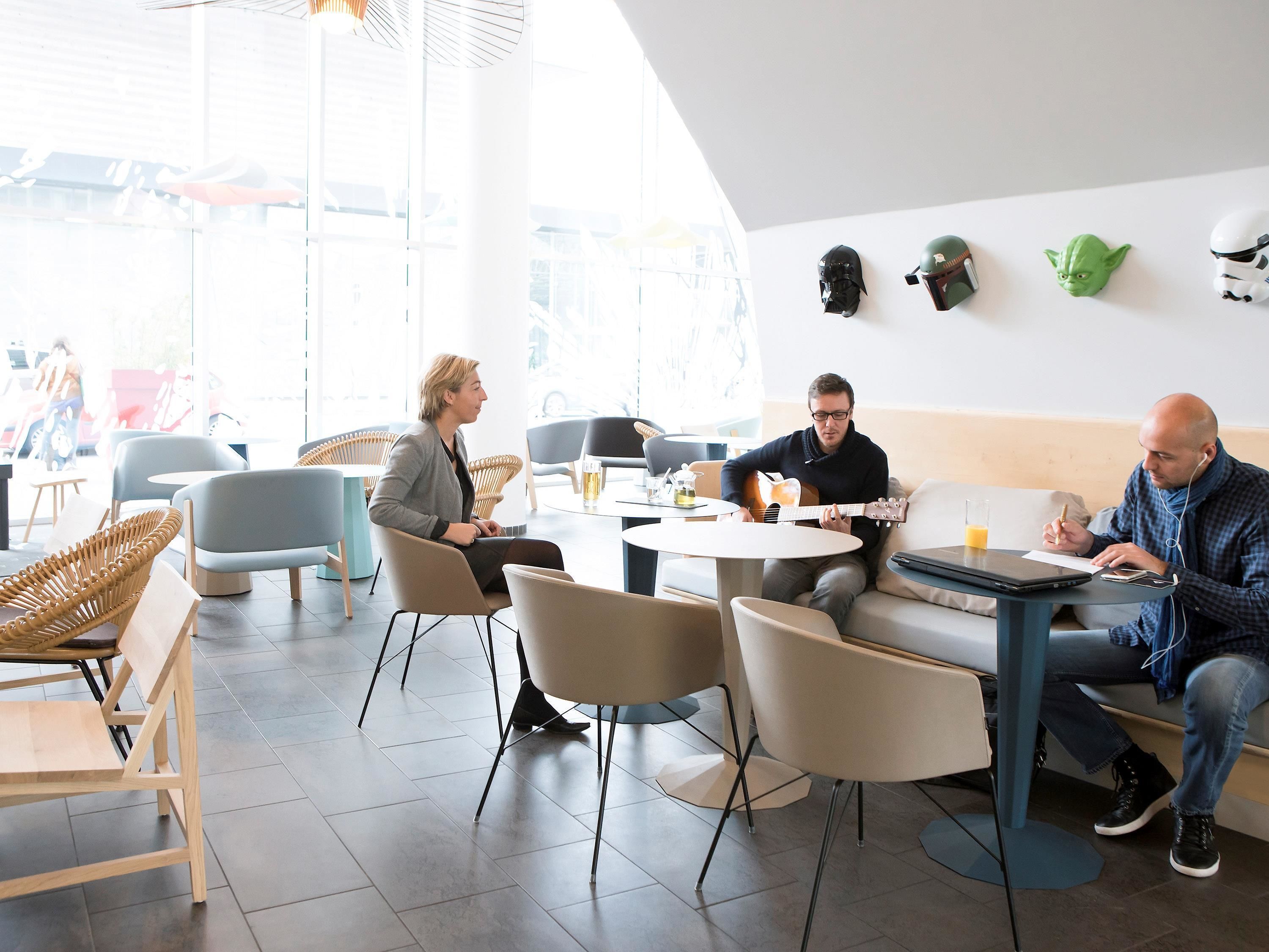 Una cafetería moderna con mesas redondas y asientos cómodos.