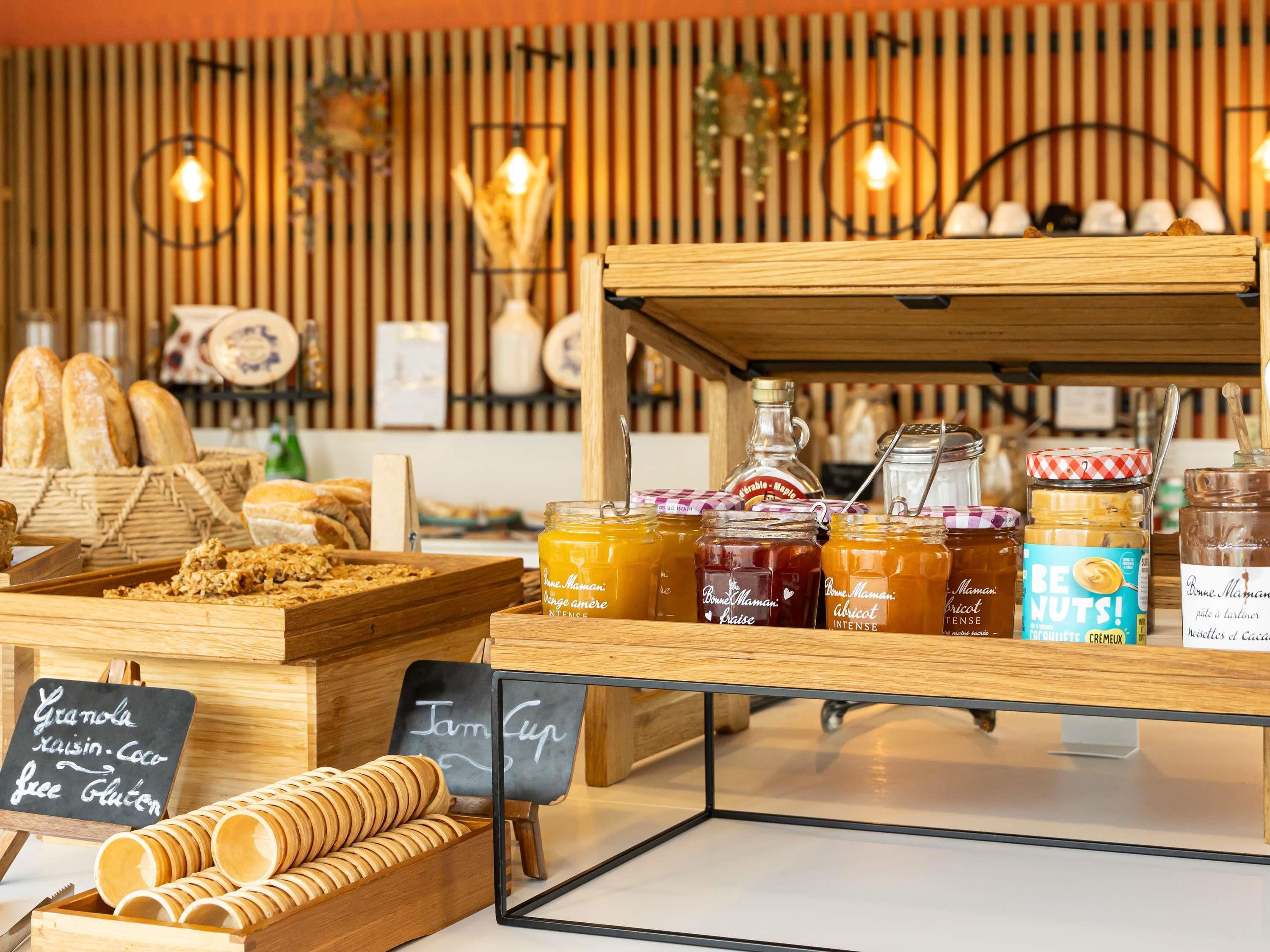 Une vitrine de boulangerie présentant diverses pâtisseries et des pots de confitures et de pâtes à tartiner.