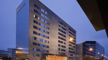 Un hôtel moderne, avec plusieurs étages et une entrée imposante.
