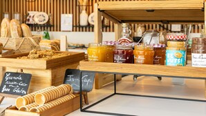 Mostrador de panadería con diversas opciones de panadería y frascos con conservas.