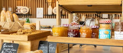 A bakery display with various baked goods and jars of spreads.