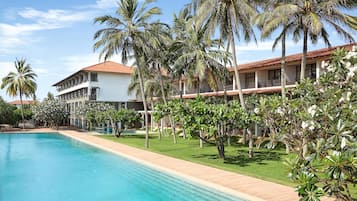 Una piscina al aire libre, sombrillas, tumbonas