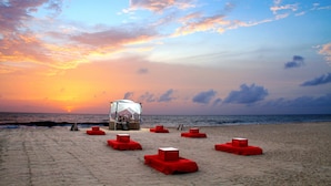 A beach with a canopy structure and red seating areas. - Jetwing Beach (Negombo)