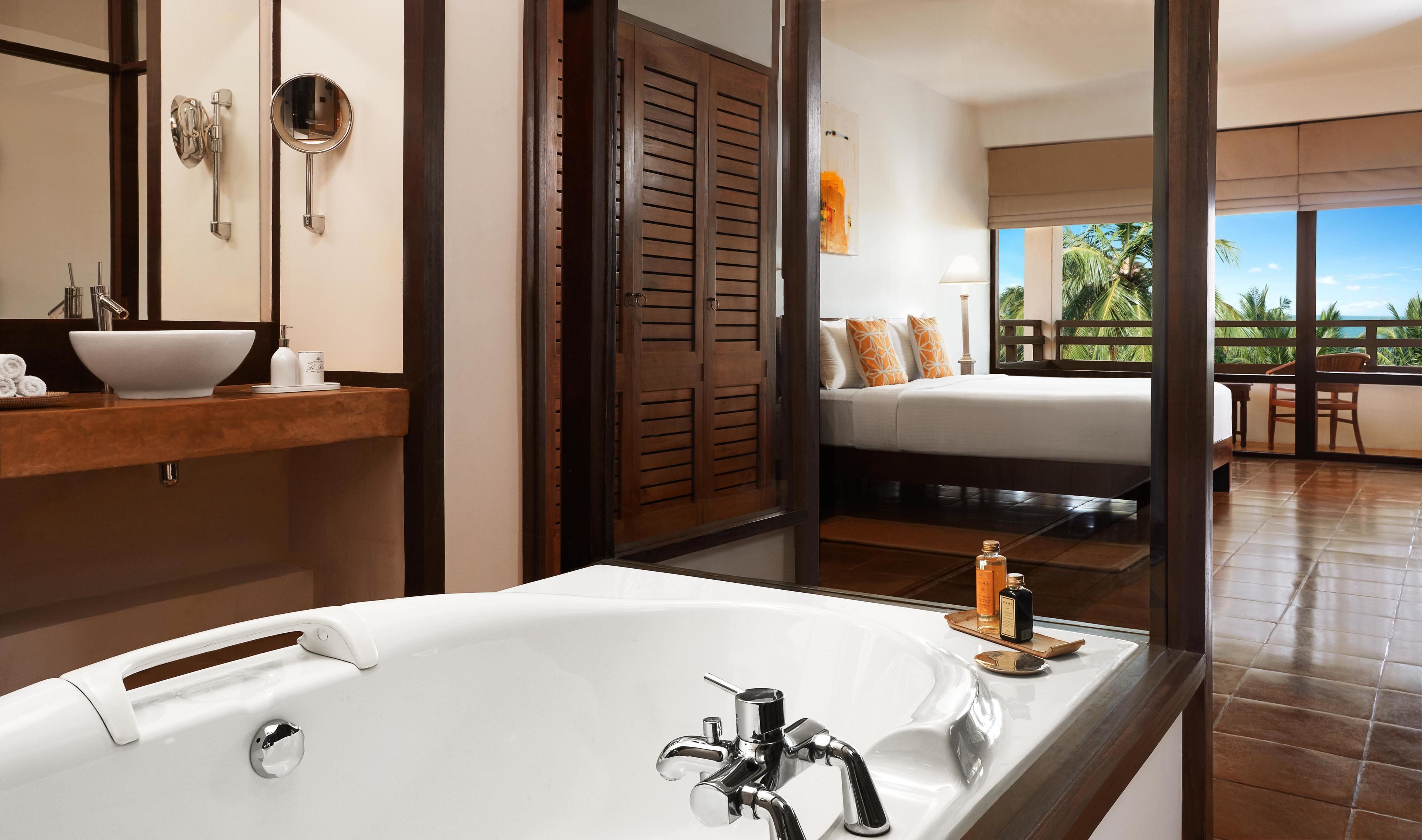 A modern bathroom with a large bathtub, a vanity with a bowl sink, and a mirror.