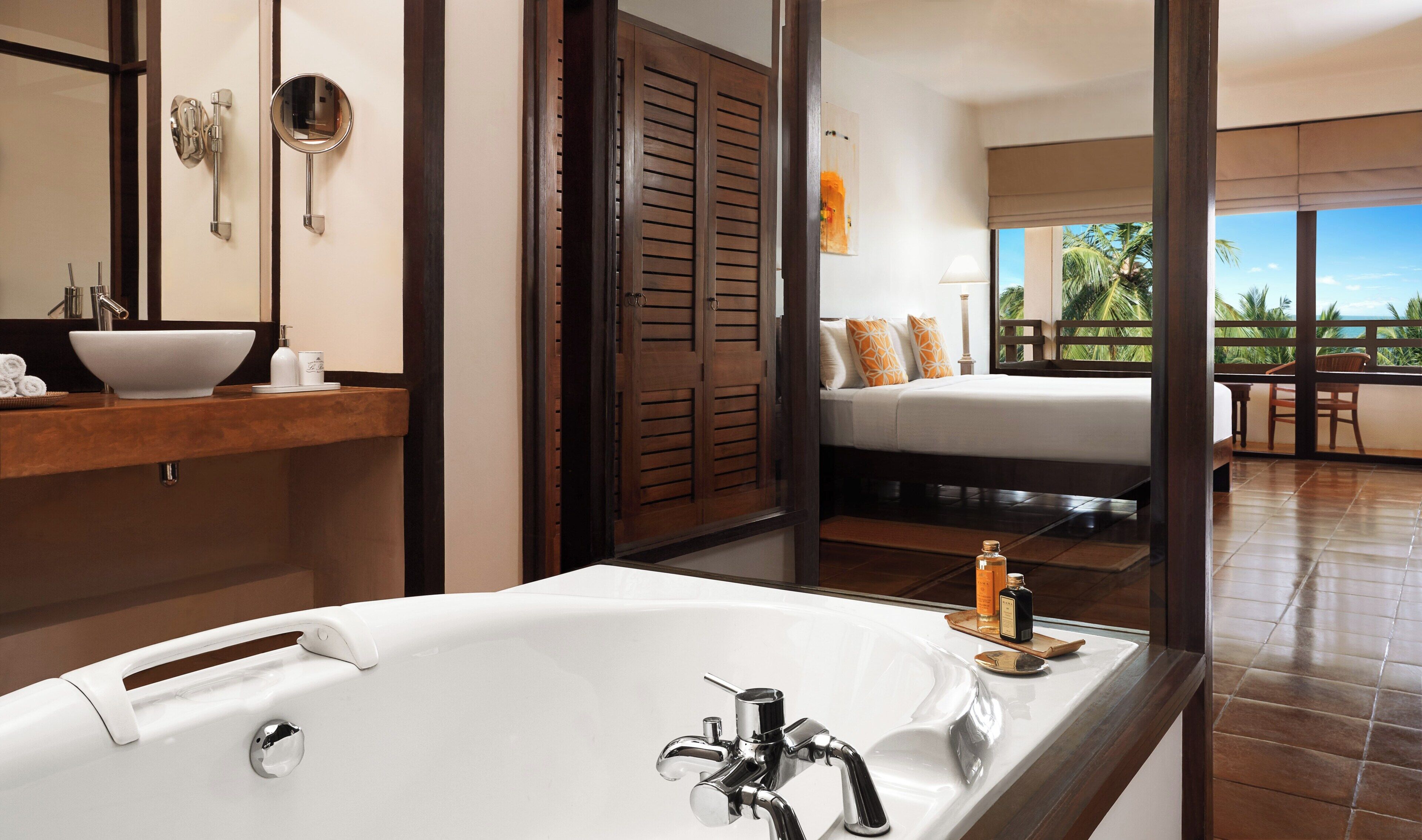 A modern bathroom with a large bathtub, a vanity with a bowl sink, and a mirror.