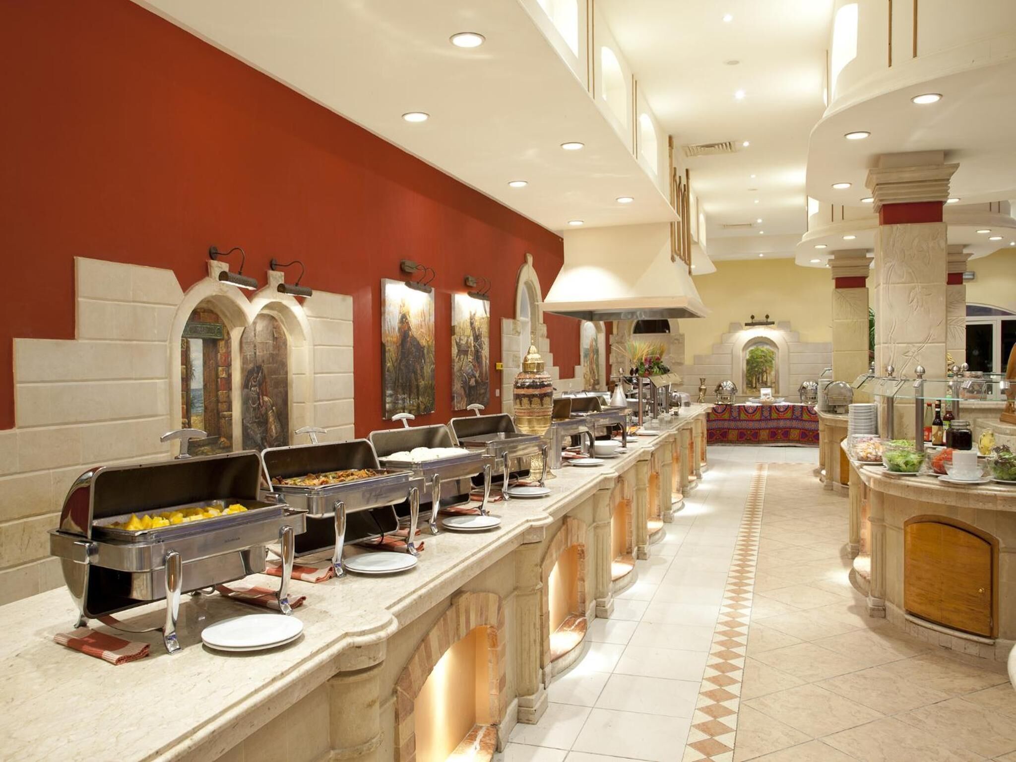 A buffet setup with multiple serving stations, a central decorative area, and a tiled floor.