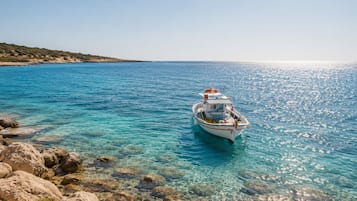 Un bateau sur une eau turquoise et limpide, avec des rivages rocheux.