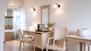 A bathroom with a shower, a sink, a mirror, and two chairs. - Lagos Mare Hotel (Naxos)