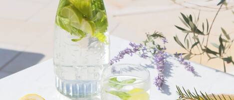 A table with a glass pitcher, a bowl of lemons, and a lemon half.