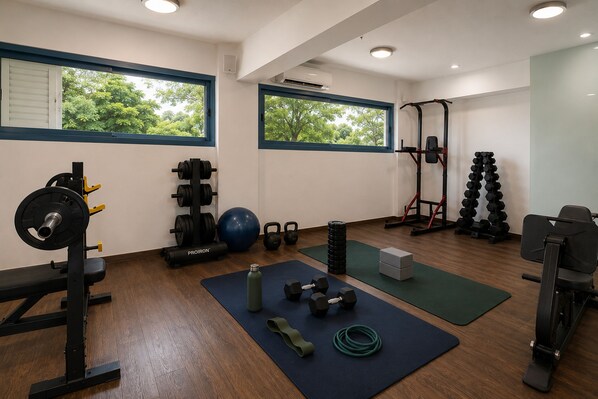 A gym with weightlifting equipment, exercise balls, and mats. - Lagos Mare Hotel (Naxos)