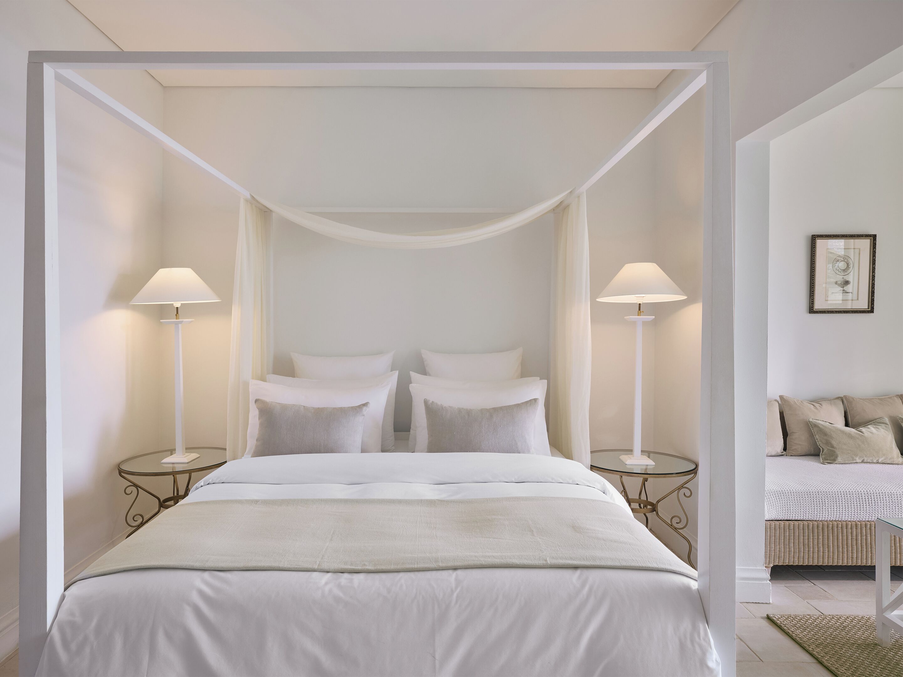 A modern bedroom with a canopy bed, two bedside tables, and a nightstand.