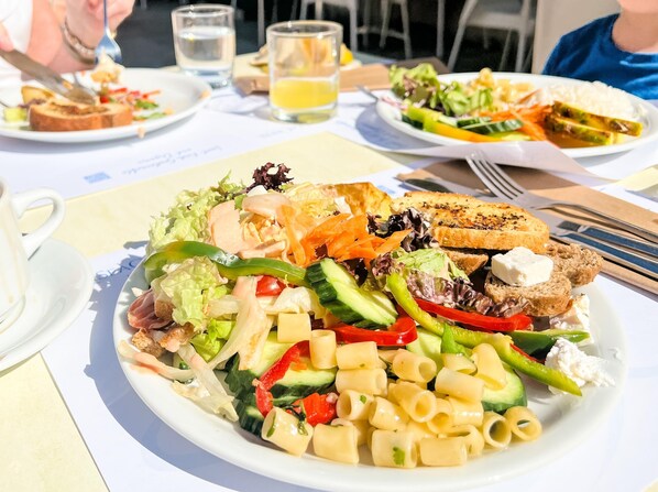 A meal with pasta salad, grilled vegetables, and a sandwich on a white plate. - Hotel Kalyves Beach (Apokoronas)