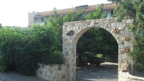 A stone archway leading to a building with a sign that reads "HOTEL ARMONIA". - Armonia Hotel (Hersonissos)