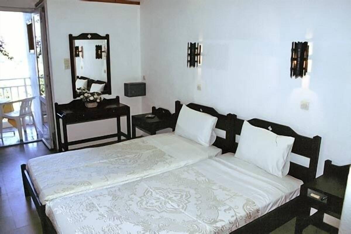 Ein Schlafzimmer mit Bett, Schreibtisch, Stuhl, Spiegel und Nachttisch.