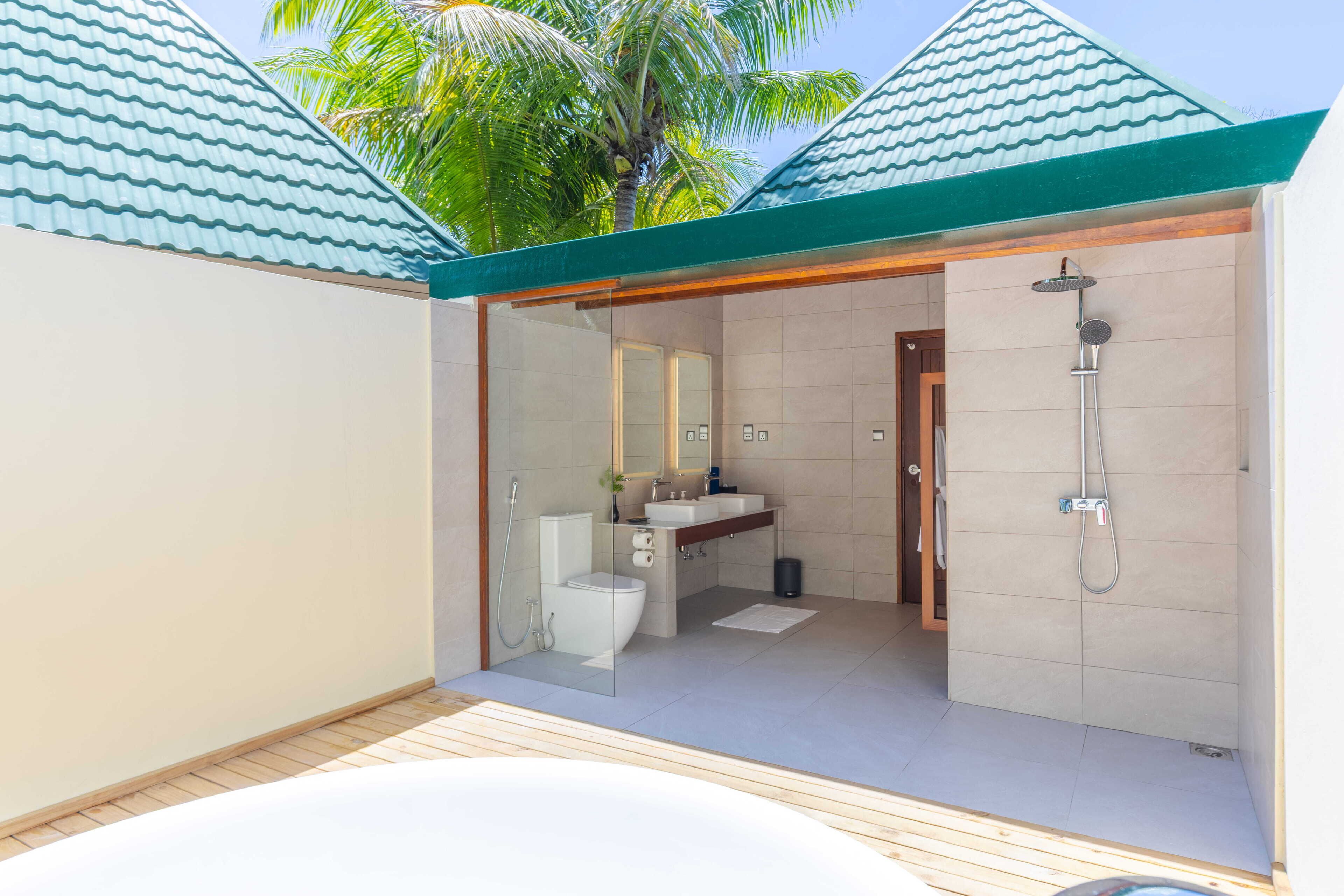 A modern bathroom with a shower, toilet, and sink.